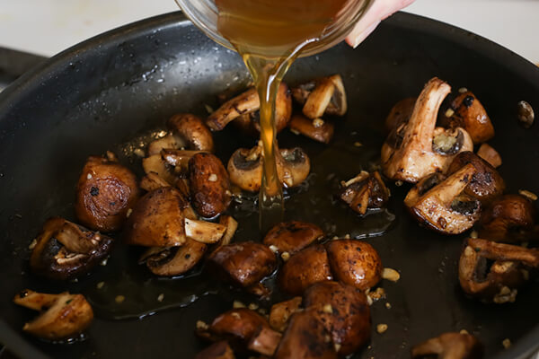 Cooking mushrooms for keto stroganoff.