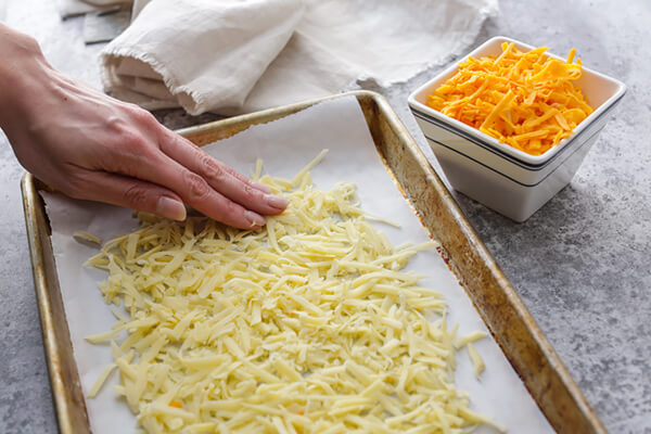 Shredded white cheese on a baking sheet.