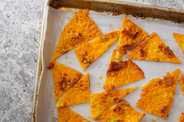 Cheese chip triangles on a baking tray.