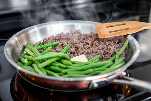 Cooking green beans and ground beef.