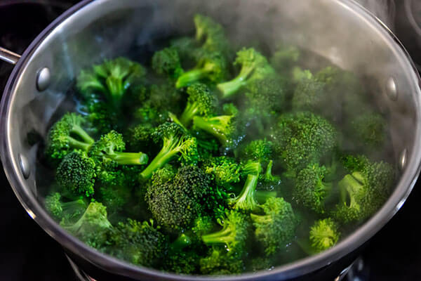 Broccoli steaming in a pot.